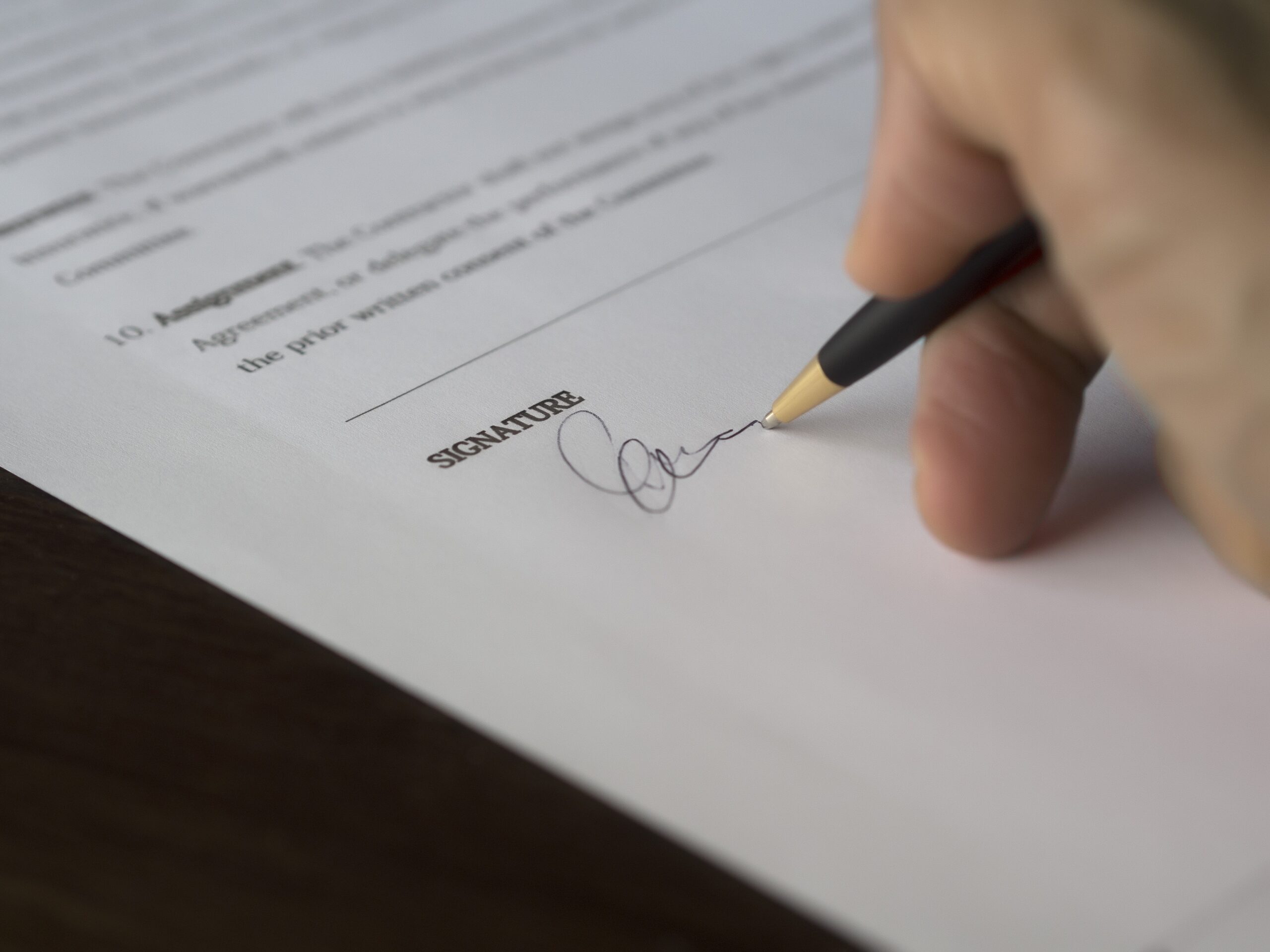 hand-signing-an-agreement-with-black-pen
