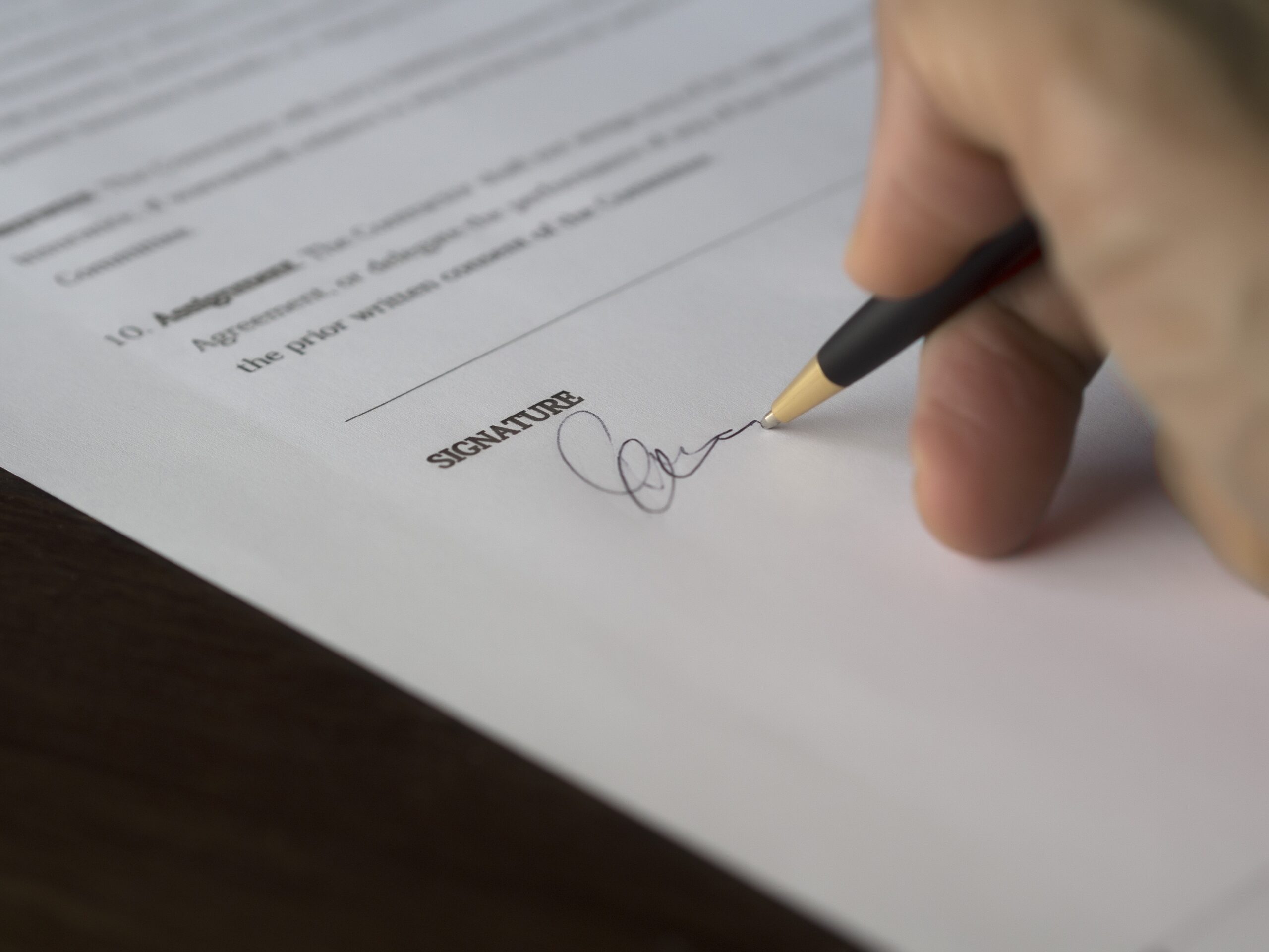 Hand signing an agreement with black pen.