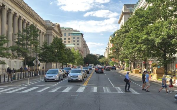 People crossing a crosswalk on a busy street in DC.