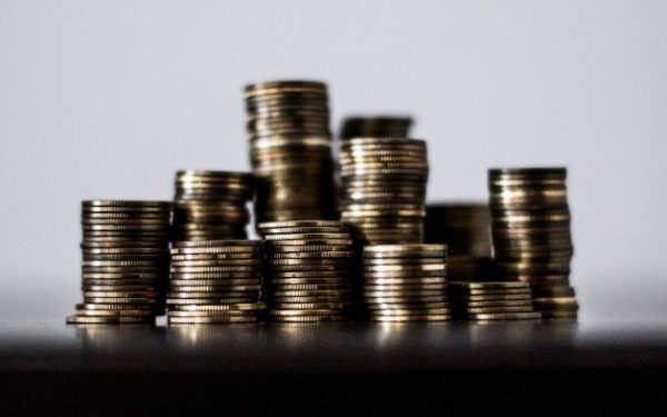 Multiple stacks of coins sitting on a blurry surface.