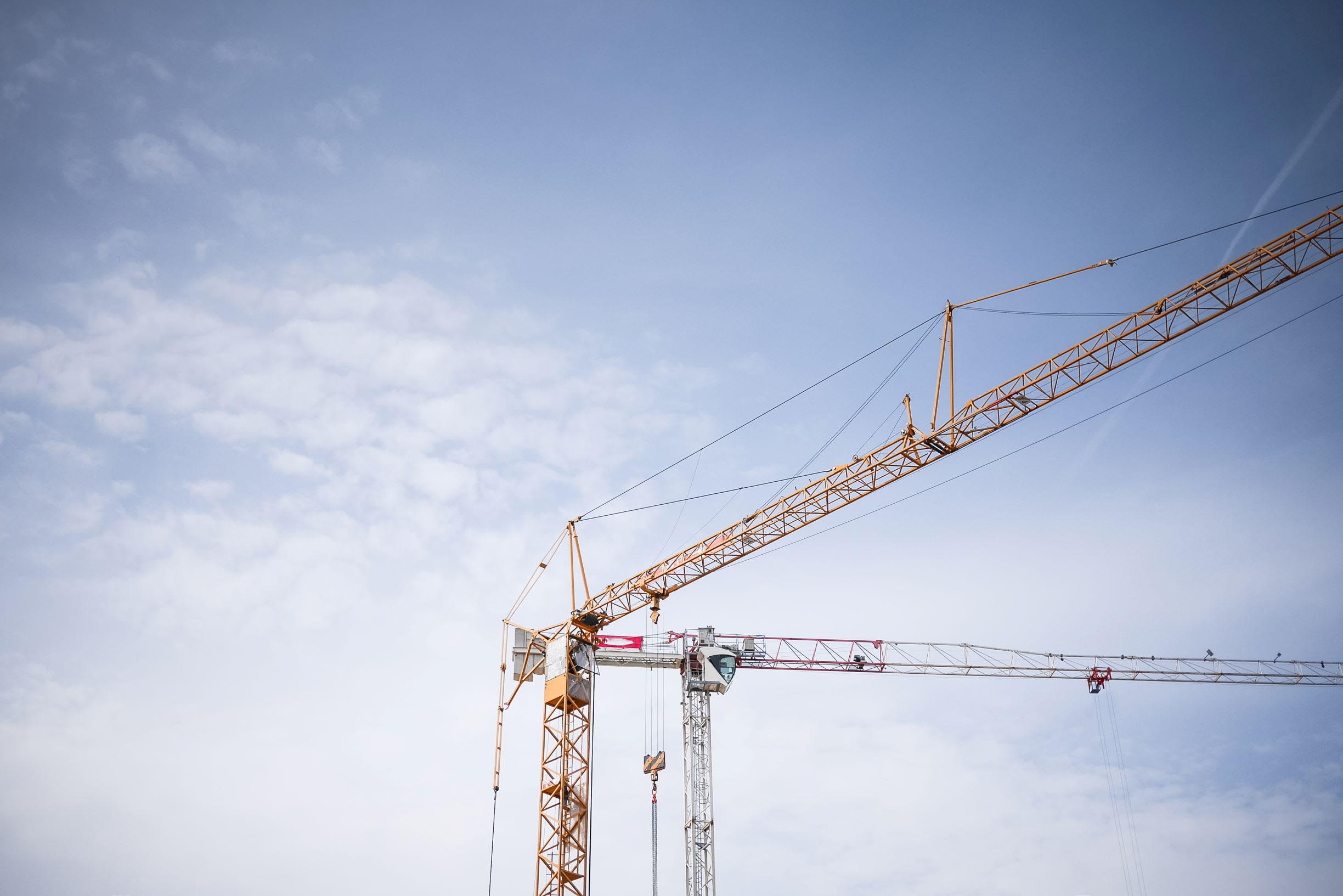 Yellow scaffolding against a blue sky with white clouds.