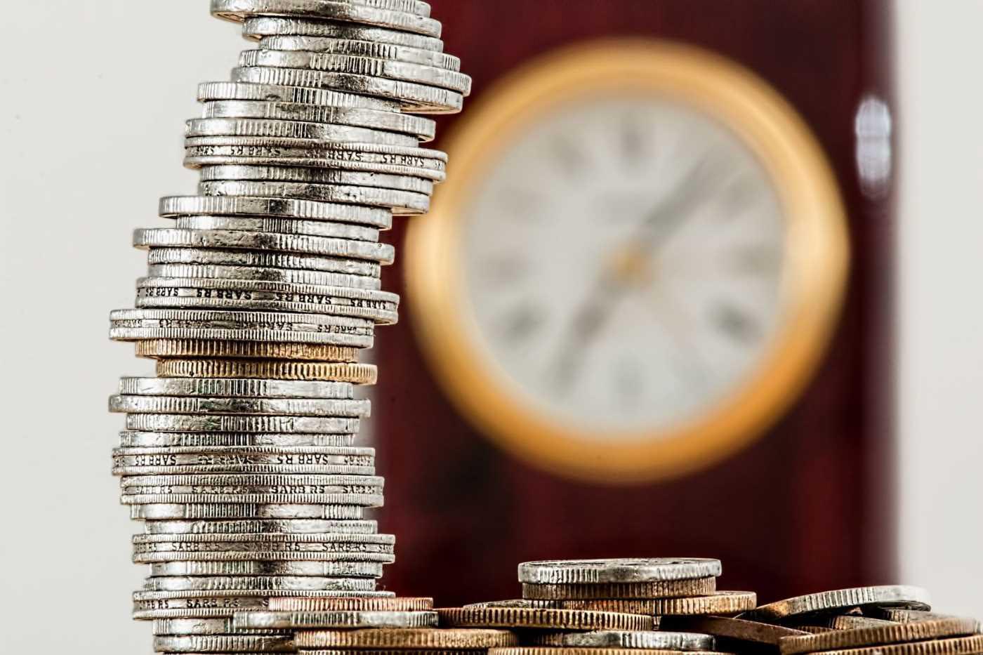 Stack of in front of a blurry clock in the background.