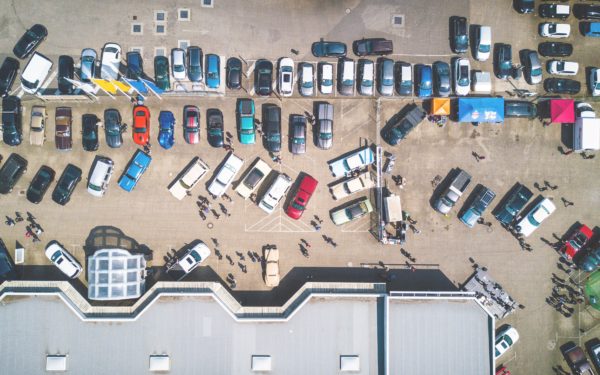 Aerial view of a non-descript building with a parking lot in front of it.