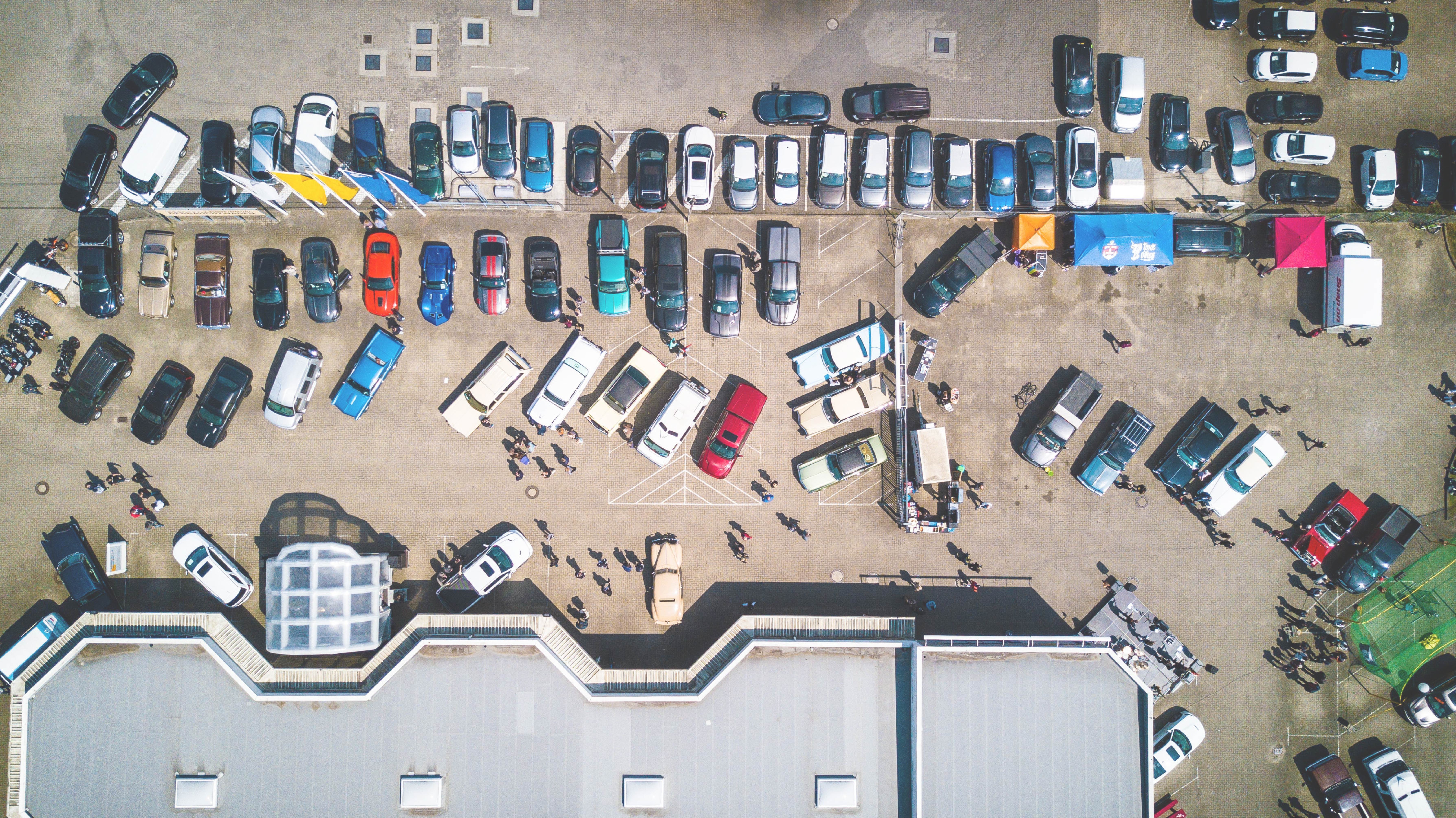 Aerial view of a non-descript building with a parking lot in front of it.