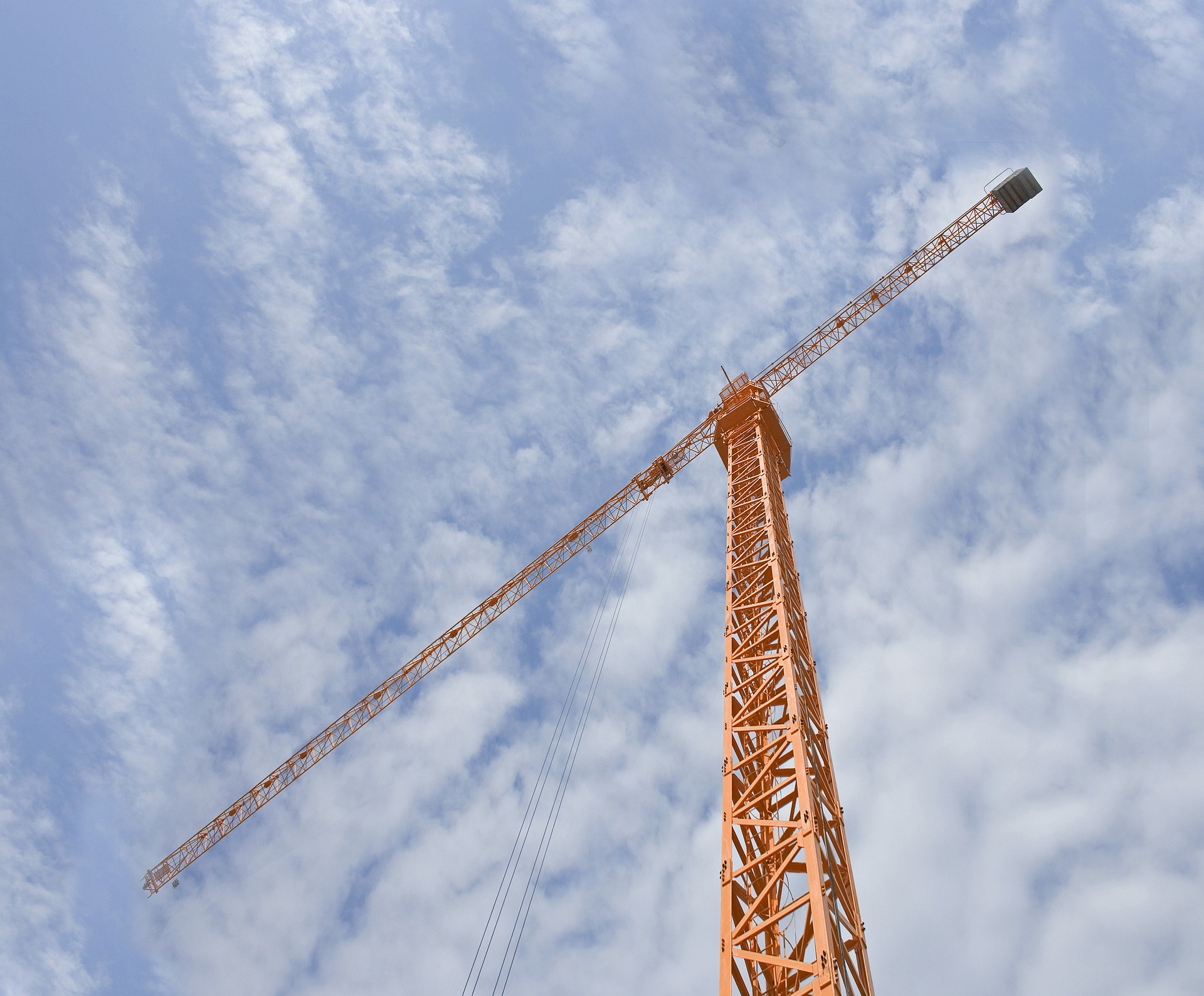 Orange scaffold against blue cloudy sky.