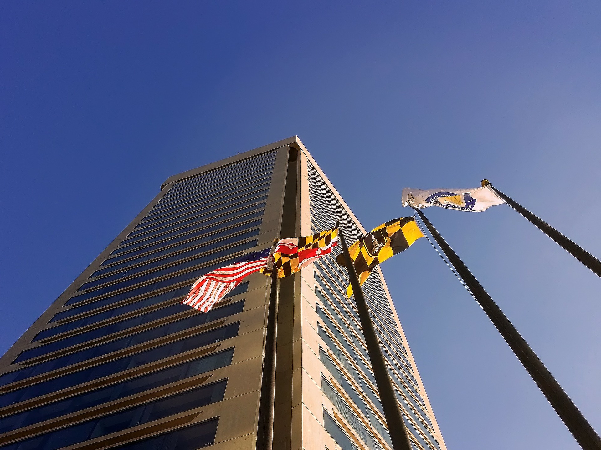 World Trade Center Baltimore with the American, Maryland, Baltimore, and unidentified flag on flagpoles.