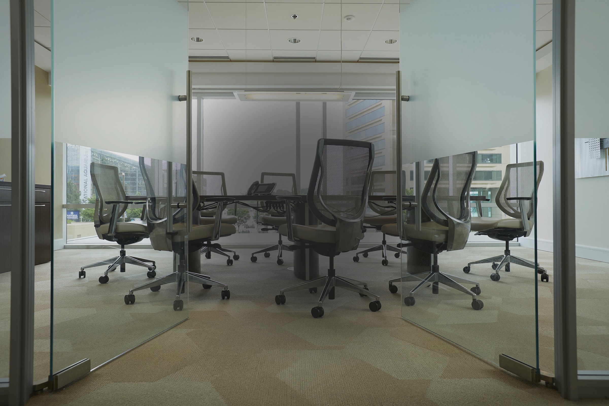 Conference room with a table and 8 rolling chairs surrounding it.