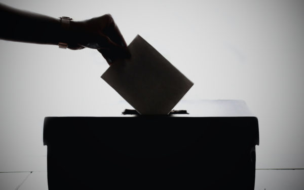 hand-putting-paper-in-ballot-box