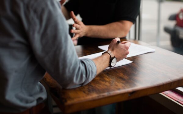 Two people having business meeting with papers on table.