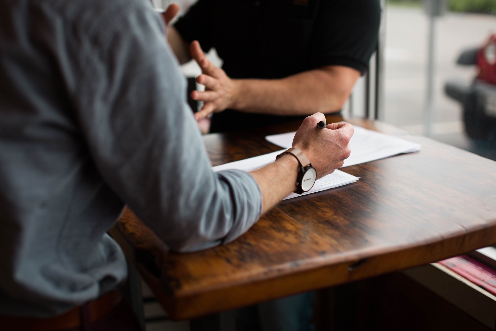 Two people having business meeting with papers on table.