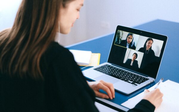 Woman sitting at desk on video call on laptop.