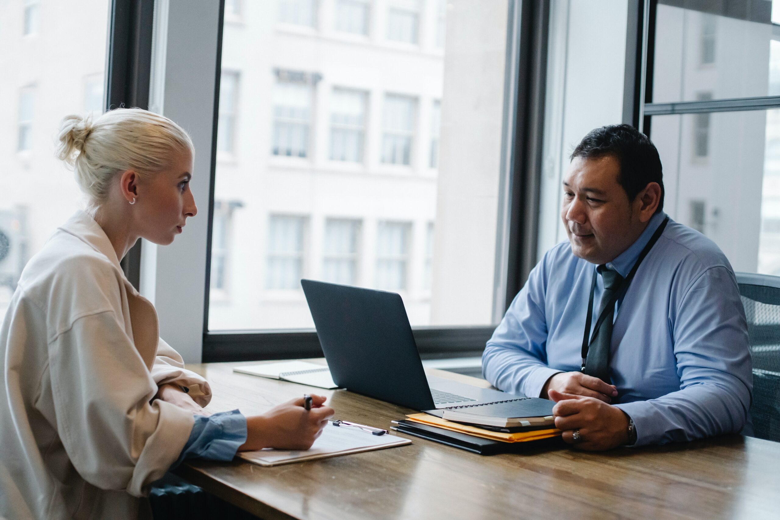 woman-sitting-across-from-man-in-office-with-laptop