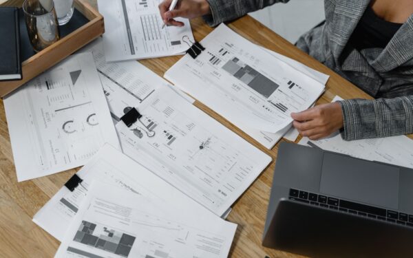 Woman sitting at desk reviewing business reports.