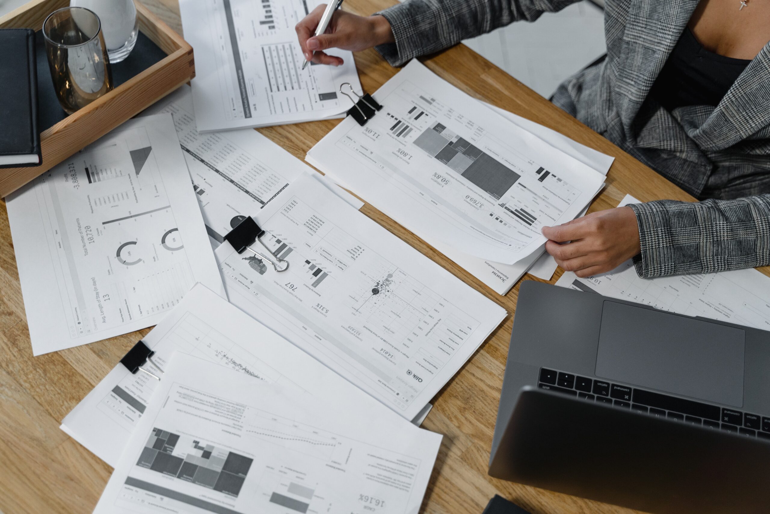 Woman sitting at desk reviewing business reports.