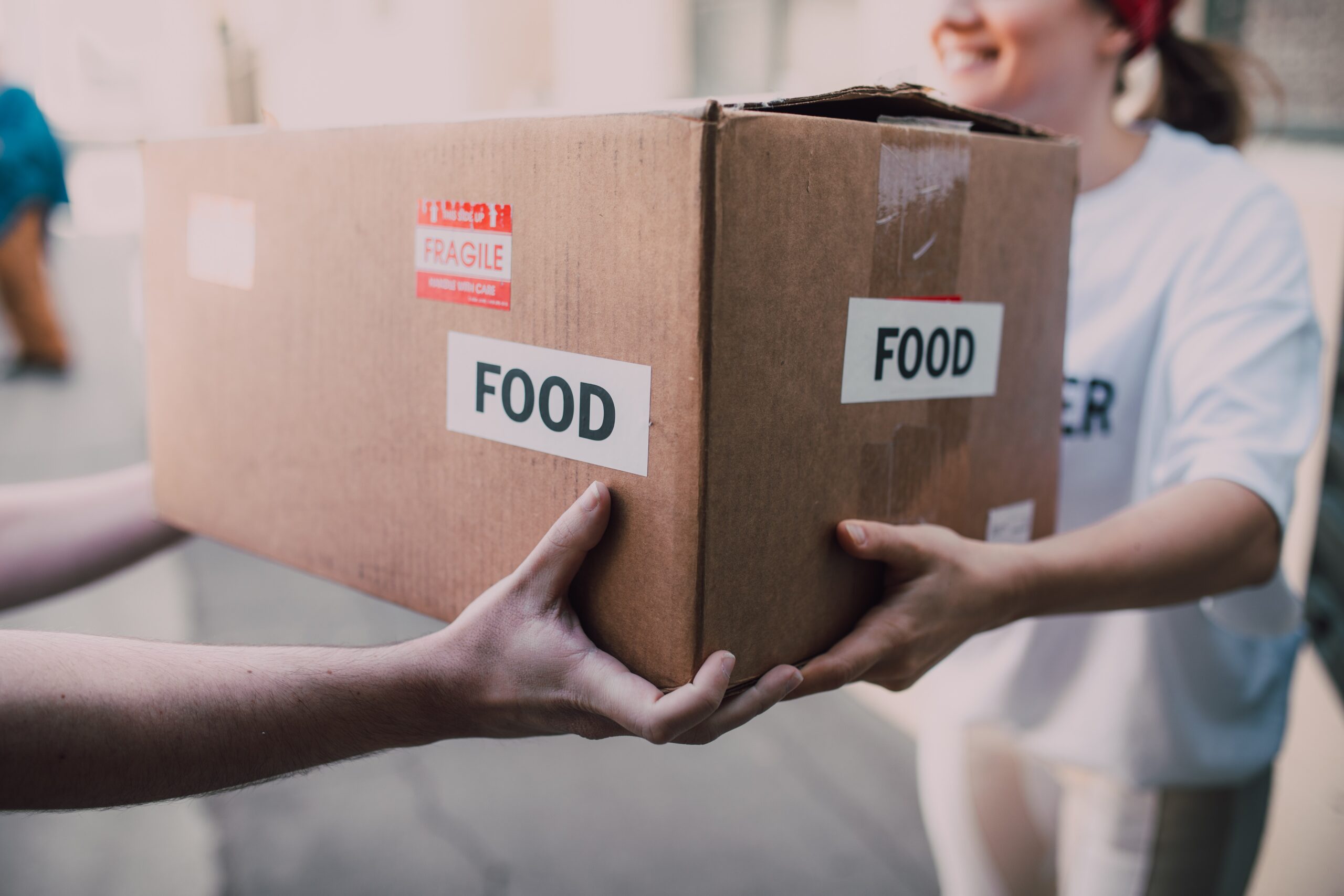 person handing another person a box of food.