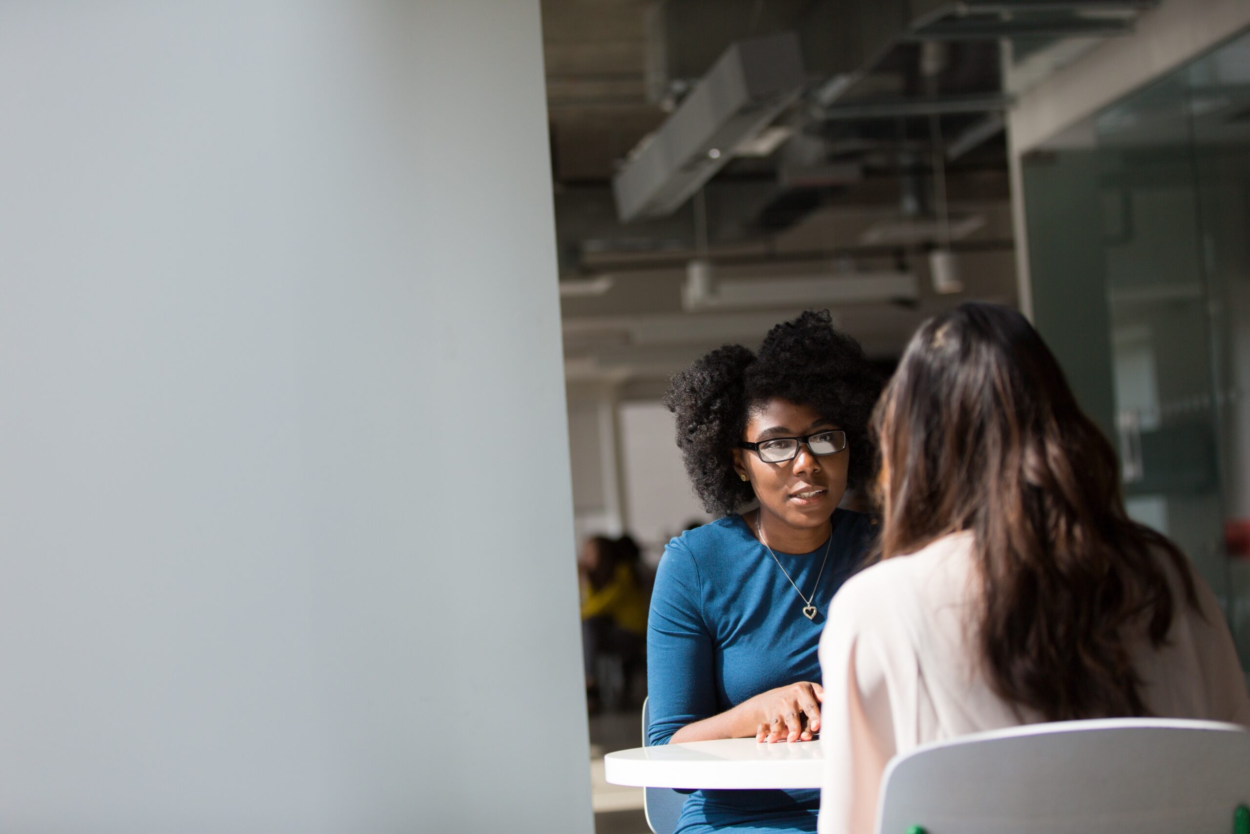 Two women sitting at a table talking.