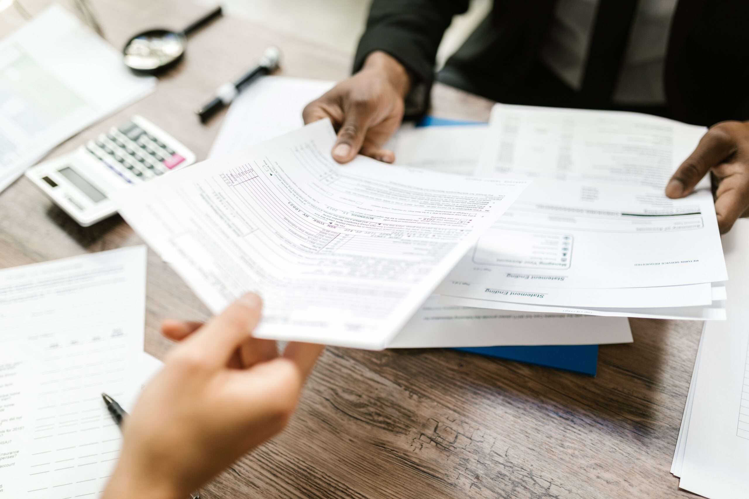 Person handing another person paperwork.