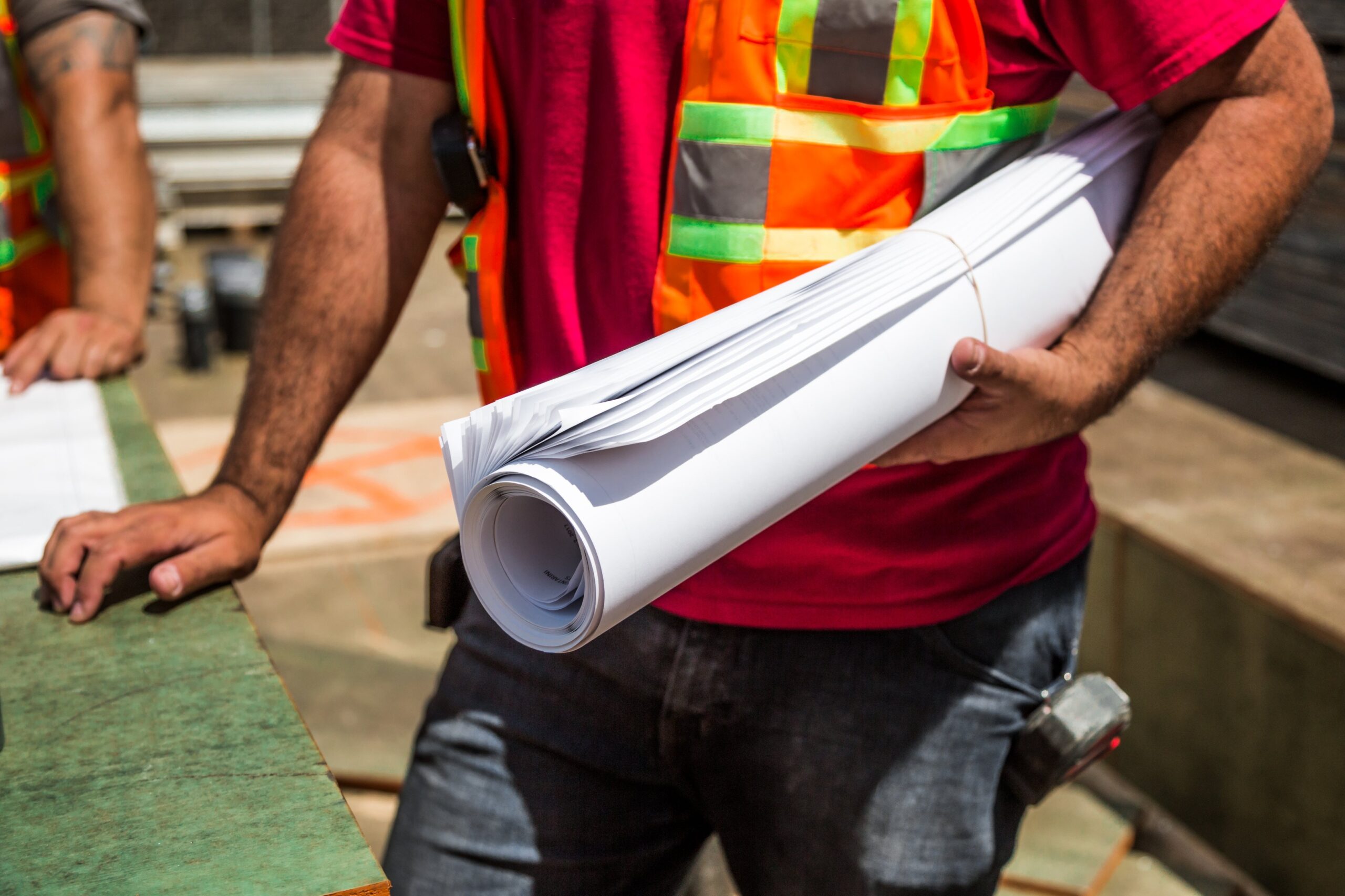 construction worked holding blue prints