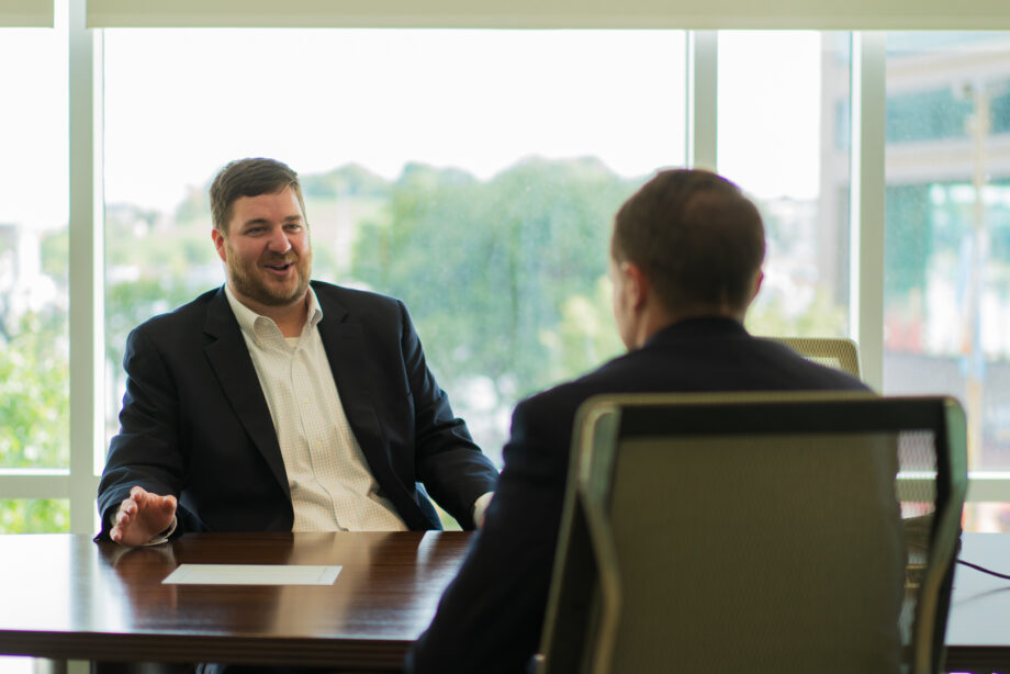 two men sitting in a job interview at conference table