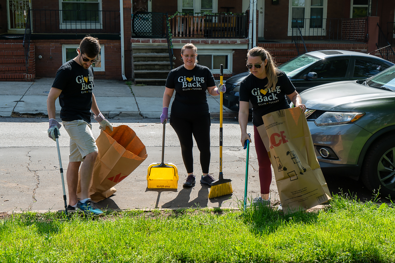 Three Ellin & Tucker employees picking up trash at Ellwood Park in East Baltimore.