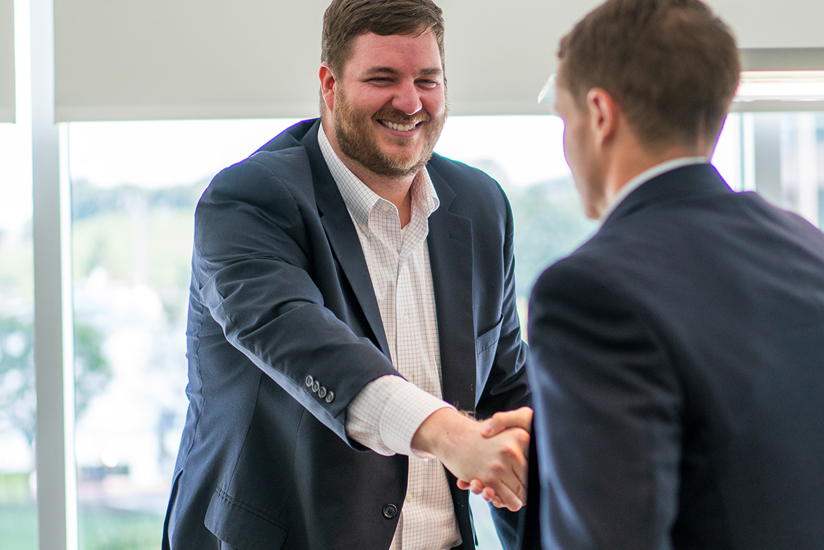 Two men in suits shaking hands.