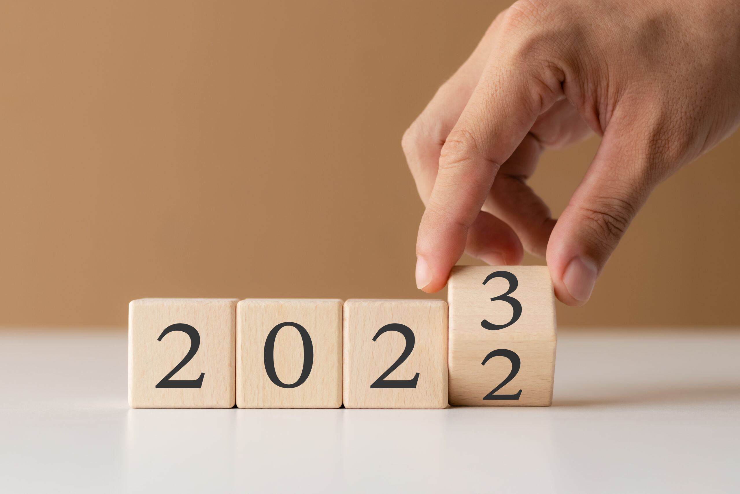 Wooden cubes that spell out 2023 on white table.