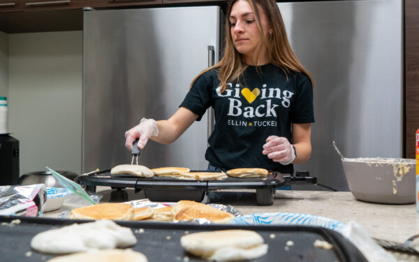 Giving Back Committee member makes pancakes at a fundraiser for St. Vincent de Paul.
