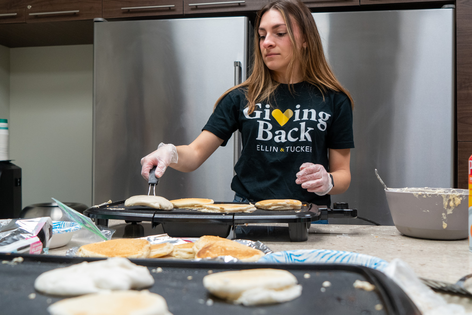 Giving Back Committee member makes pancakes at a fundraiser for St. Vincent de Paul.