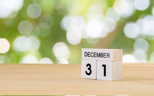 White blocks that say December 3 1 on them sitting on a wooden table.