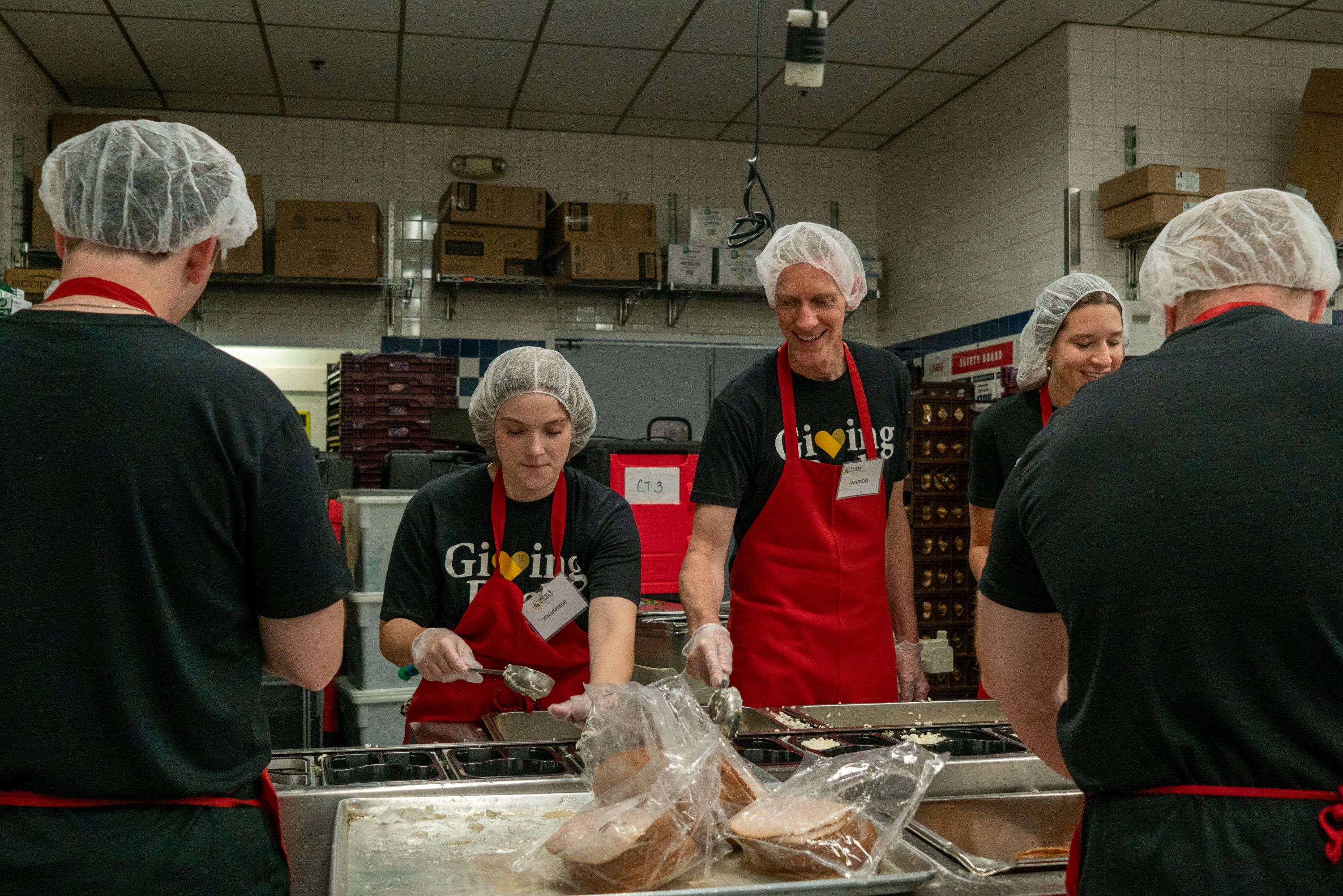 Mia Applegate and David Schriver packaging meals at Meals on Wheels of Central Maryland