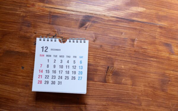 small white calendar with December page sitting on wooden surface