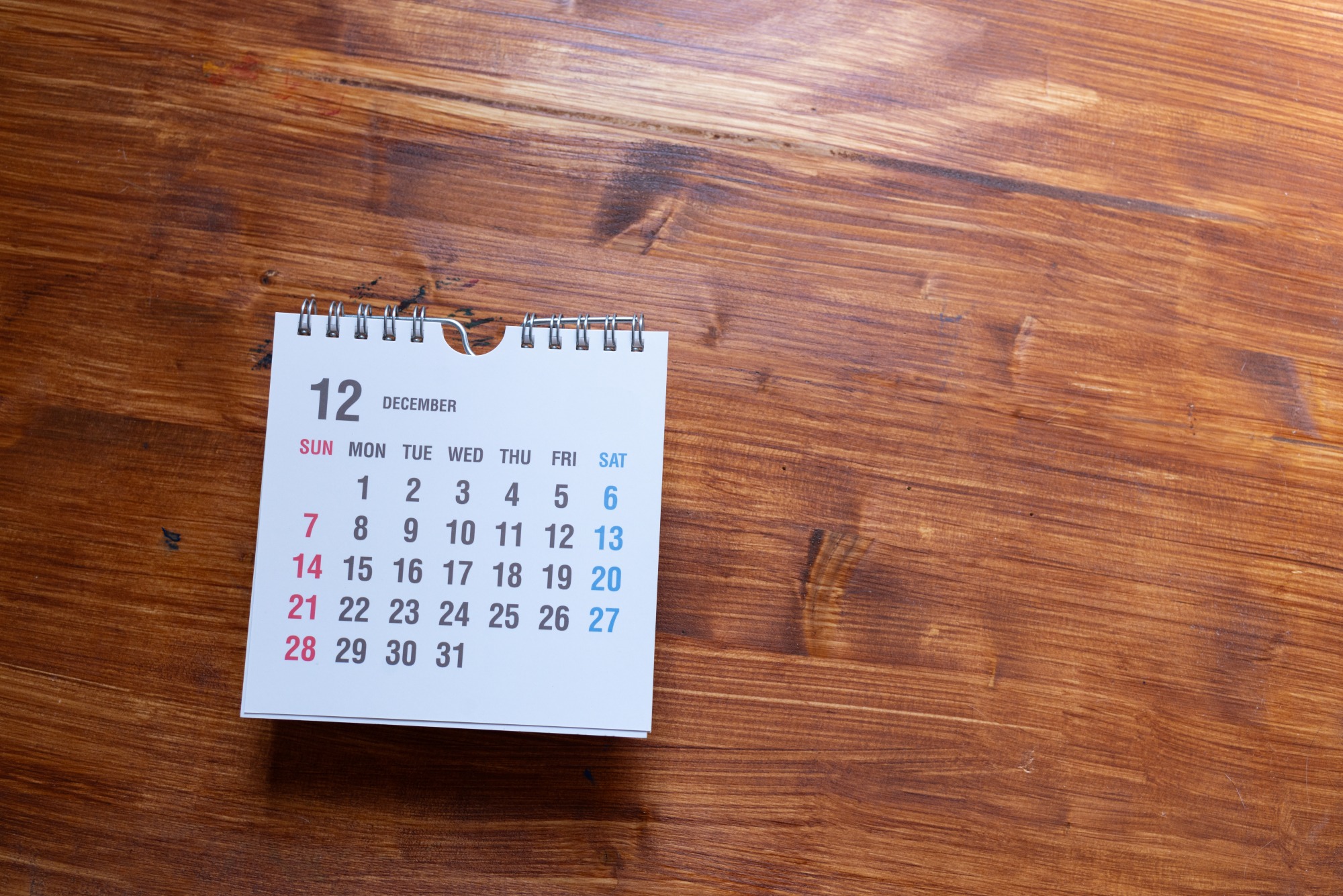 small white calendar with December page sitting on wooden surface