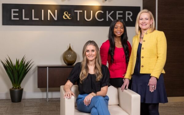 Renee Collins, Jayla Prince, and Aileen Eskildsen stand in the lobby of Ellin & Tucker