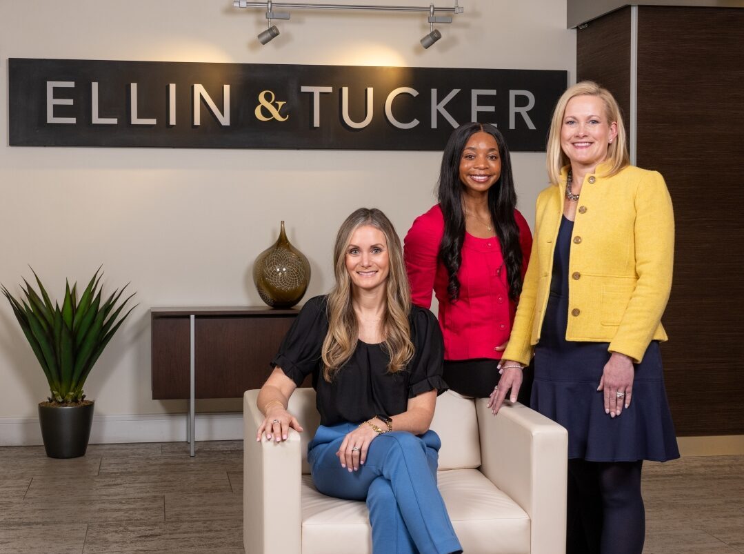 Renee Collins, Jayla Prince, and Aileen Eskildsen stand in the lobby of Ellin & Tucker